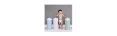 toddler-standing-in-front-of-three-diaper-pails