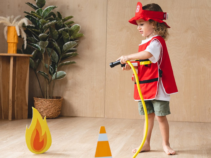 child playing firefighter with play set from plan toys